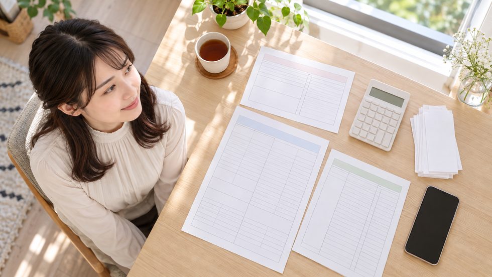 確定申告の書類と領収書、電卓を机に並べて整理している様子